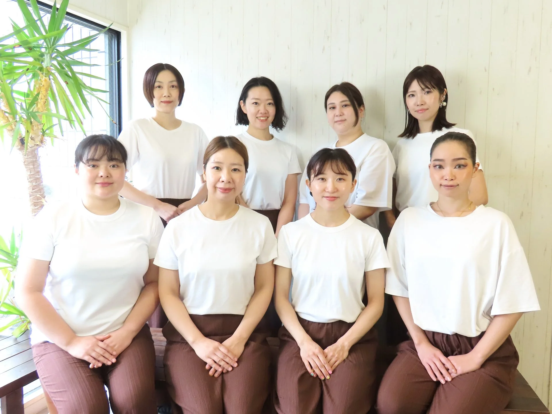 白い制服を着た女性セラピストが店内で自然に立っている様子